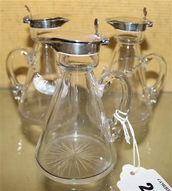 A set of three Edwardian silver mounted glass whisky tots by Hukin & Heath,